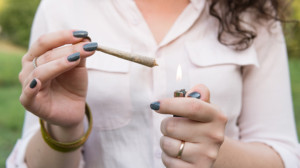 A woman lights a joint.